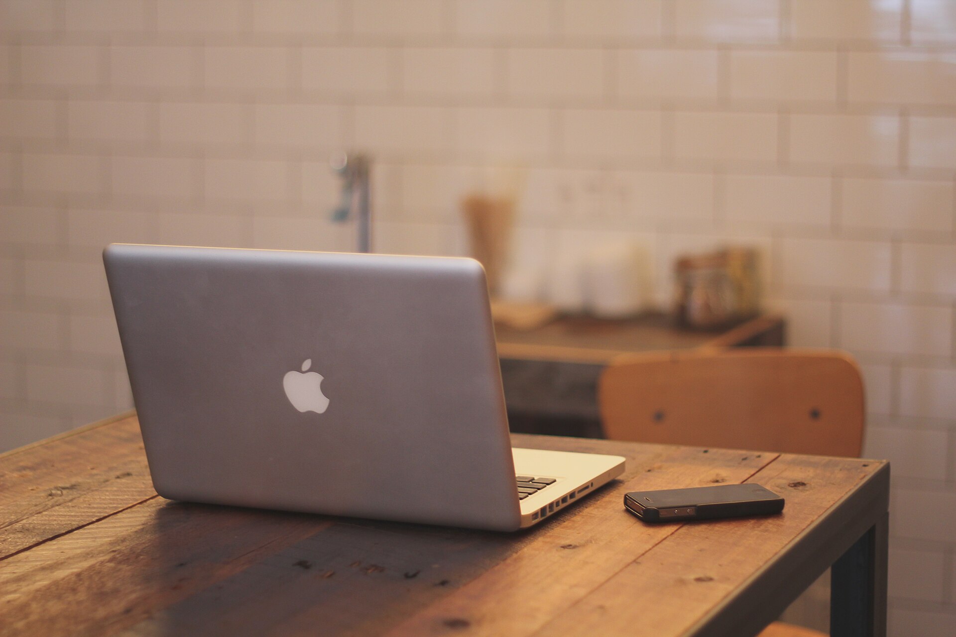 Laptop and smartphone side by side on a wooden table